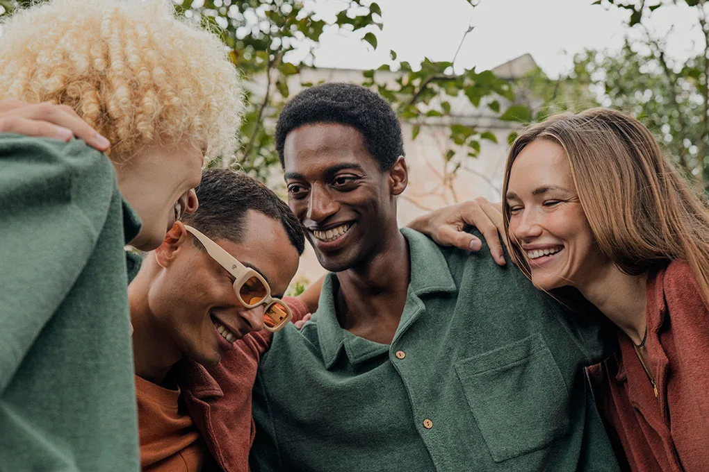 dedicated-bio-streetwear 4 Freunde in Kleidung von Dedicated Streetwear umarmen sich und lachen