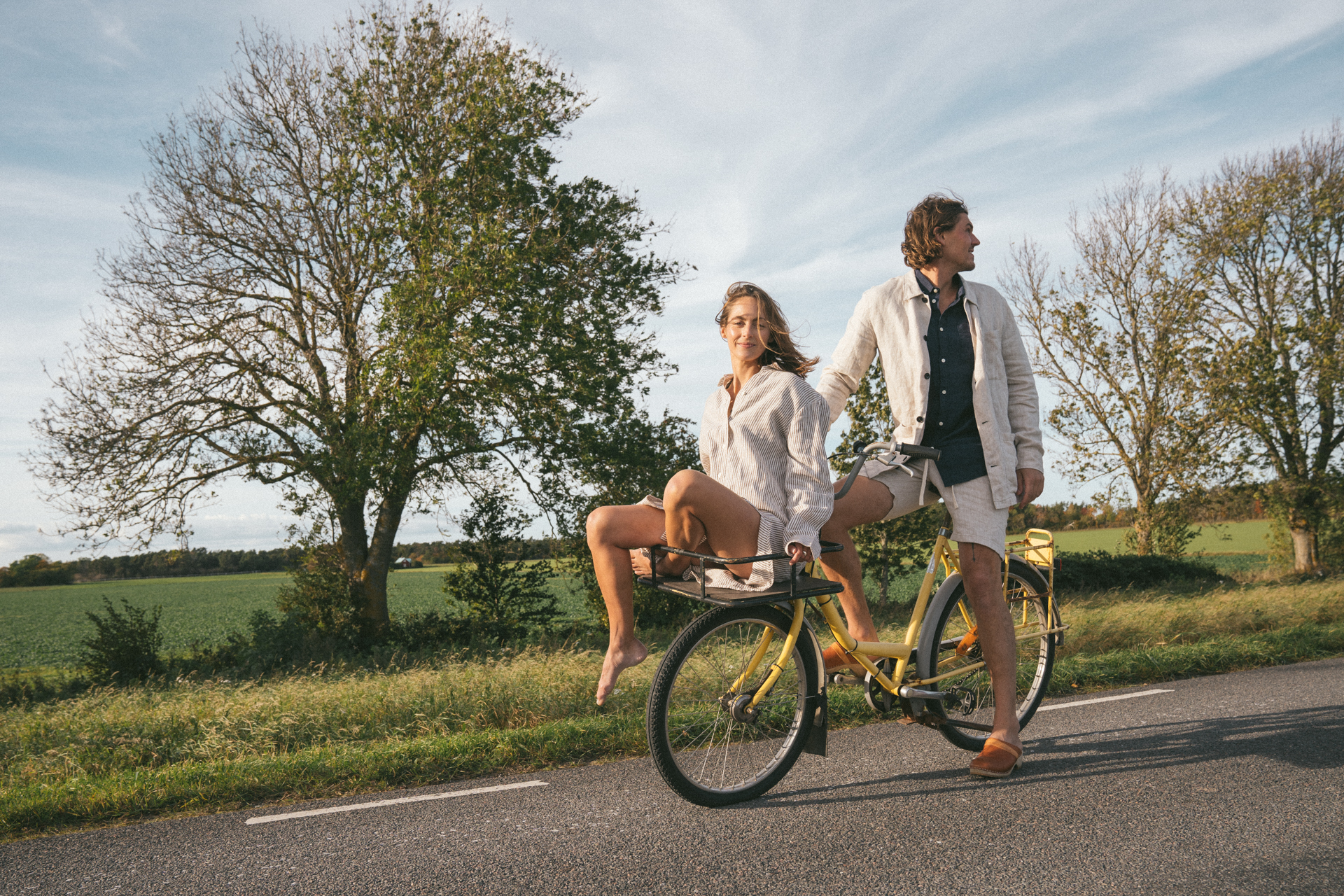 zündstoff Leinenkollektion Mann und Frau auf einem Fahrrad auf einer Landstraße